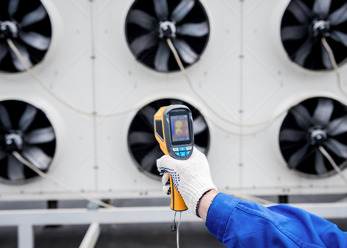 technician-uses-a-thermal-imaging-infrared-thermometer-to-check-the-condensing-unit-heat-exchanger